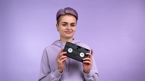 Trendy Female Person Turning VHS Cassette Tape in Hands Isolated