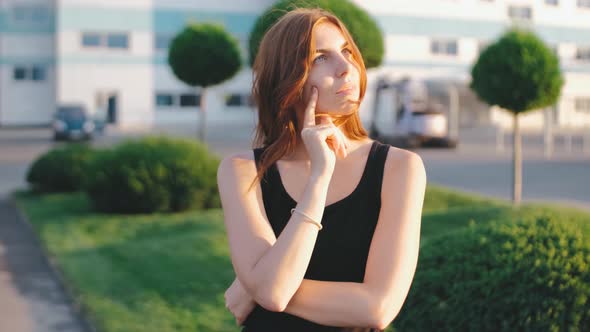 Portrait of Beautiful Smiling Redhaired Woman on Street at Sunset