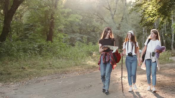 Group of Hikers with Map Going in the Forest