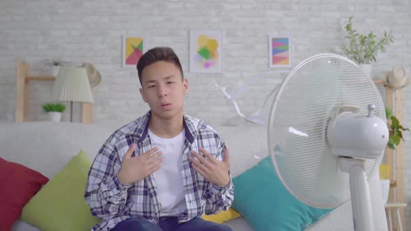 Young Asian Man Saved From the Heat Sitting in Front of a Working Fan the Concept of Heat Slow Mo