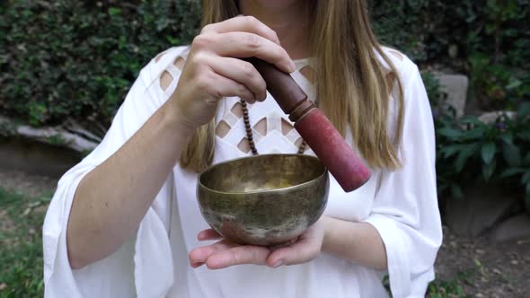 Woman Meditating with Singing Bowl