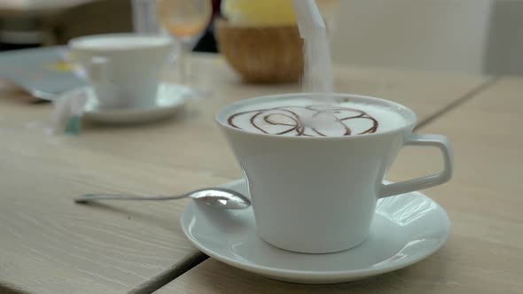 Adding sugar to the coffee served in cafe