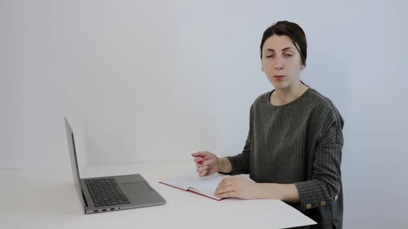 Young Teacher Uses Laptop for Learning Writes Down Useful Information