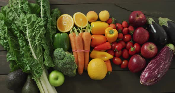 Video of fresh colourful fruit and vegetables on wooden boards in background