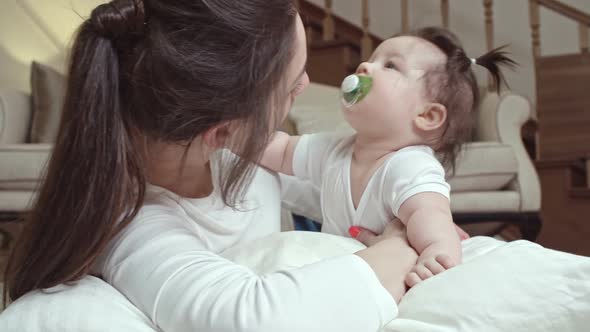 Mother Kissing Baby with Soother