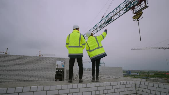 Man and Woman are Watching Work of Building Machinery in Construction Site Civil Engineer and