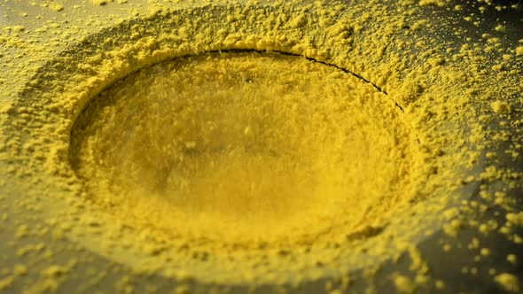 Yellow Holi Paint Powder Jumps and Pours on Large Subwoofer