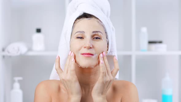 Woman Looking at Camera and Making Mask with Hyaluronic Acid on Face