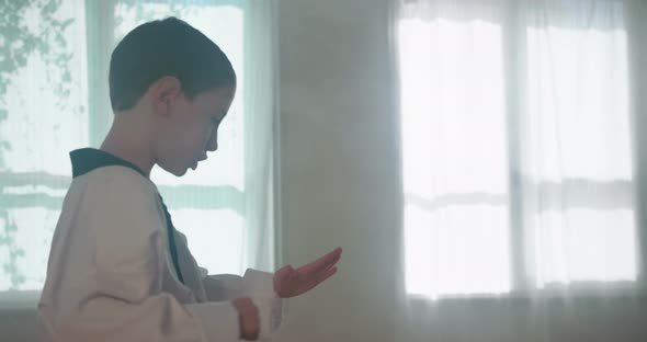 Slow motion footage of a young boy practicing martial arts inside a dojo