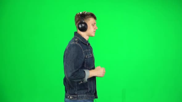 Handsome Guy in Big Headphones Is Running, Chroma Key. Slow Motion. Side View