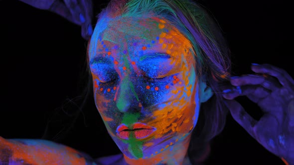 A Magical Space Girl with UV Drawings on Her Face and Body in the Dark