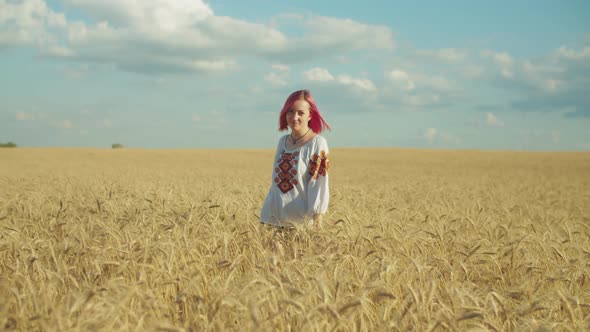 Elegant Woman Walking in Wheat Field at Sunset