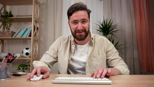 A Man Plays on a Computer in Games Celebrates a Victory Points to the Camera with His Index Fingers