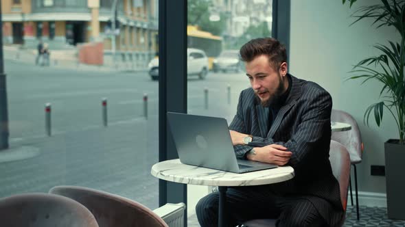 Funny man is negotiating a zoom call in a coffee shop.Freelancer, businessman.