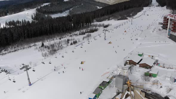 Aerial View on Lot of People Skiing on Ski Slopes Near Ski Lifts on Ski Resort