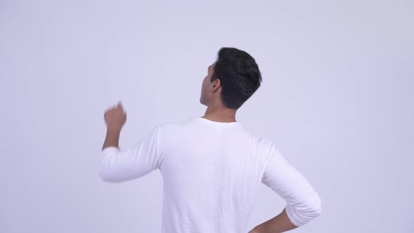 Rear View of Young Indian Man Pointing Finger
