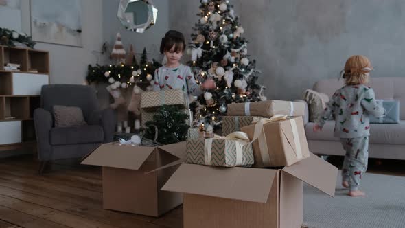 Little Boys Put Gifts in Cardboard Boxes Playing Christmas