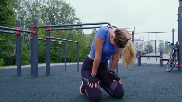 Fit Girl Sits on Her Knees After Hard Workout