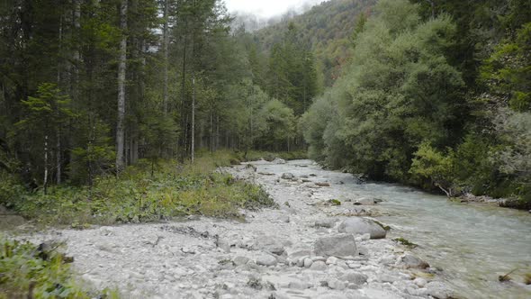 Aerial view of Fast Moving River with Rapids Surrounded by Forest