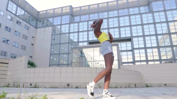 Young woman dancing in front of house