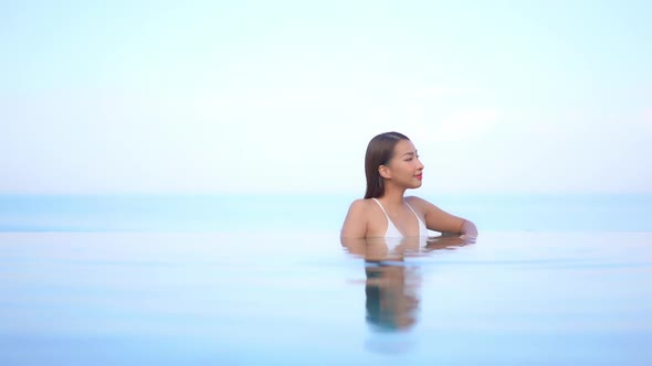 Young asian woman enjoy around outdoor swimming pool for leisure