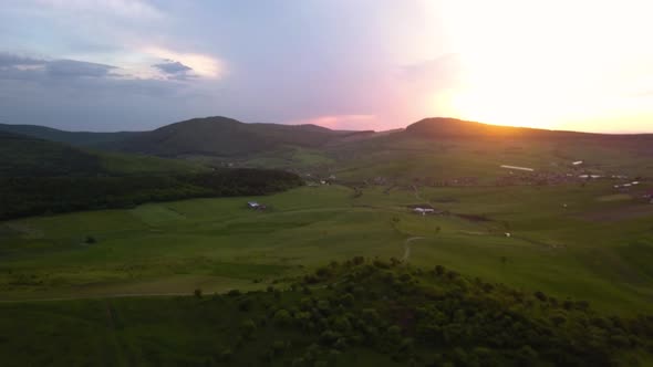 Aerial view of a colorful and majestic sunset in the hilly region of Sigmir Romania