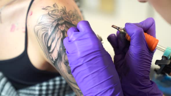 Tattoo artist tattooing an arm