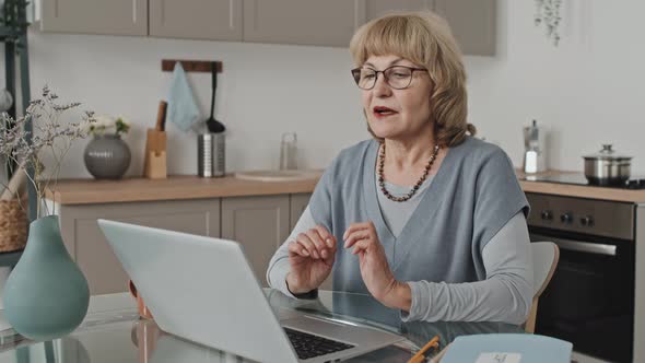 Elderly Woman Speaking on Video Call on Laptop