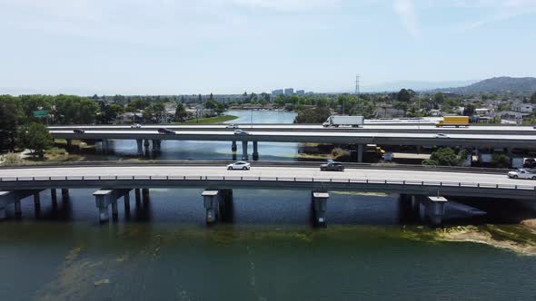 Overtake Shot Of Two Bridges Busy With Cars Crossing Over Beautiful Long Lagoon, San Mateo, Californ