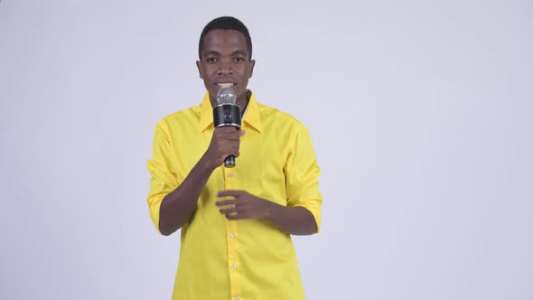 Young African Businessman As Host Using Microphone and Making Mistake