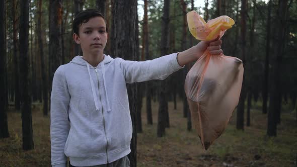 Volunteer Showing Garbage Bags After Cleaning Forest