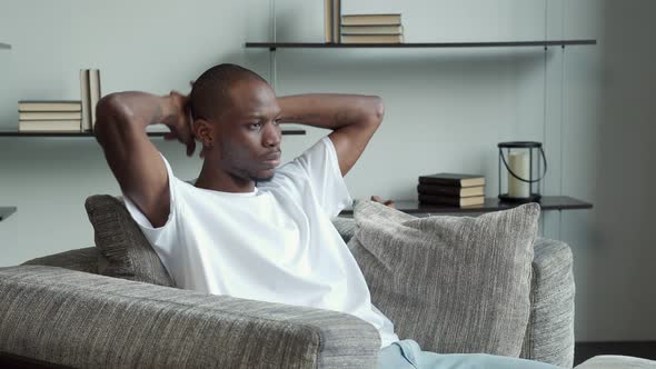 Satisfied Black Man Leaning Back in His Chair Hands Behind His Head Relaxing and Evaluating