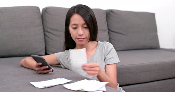 Woman counting the expenditure with cellphone