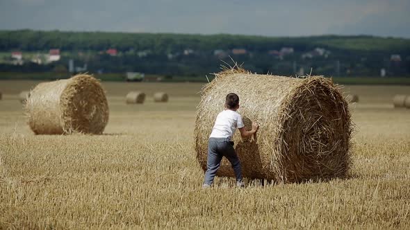 Child On A Field Against Straw. Happy child on a field with bales harvest