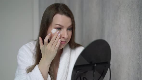 Young Woman Takes Care of Skin of Face