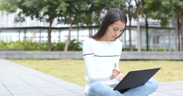 Young Woman using on laptop computer at outdoor