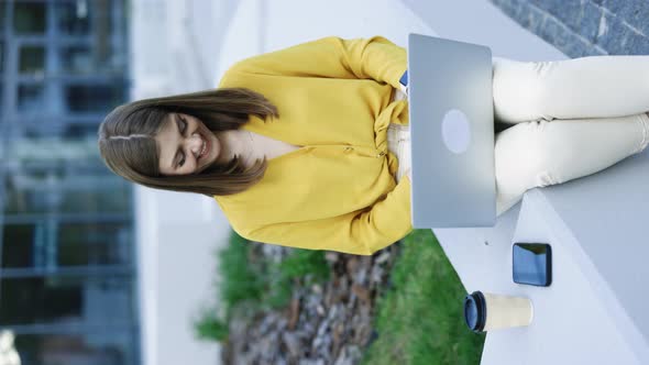 Vertical Video of Young Caucasian Business Woman Freelancer Sitting on Bench Working with Laptop