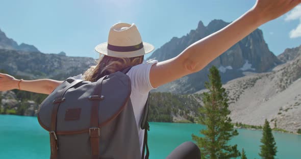 Woman Enjoying Nature and Lake with Mountains View. Back View Traveler in Nature