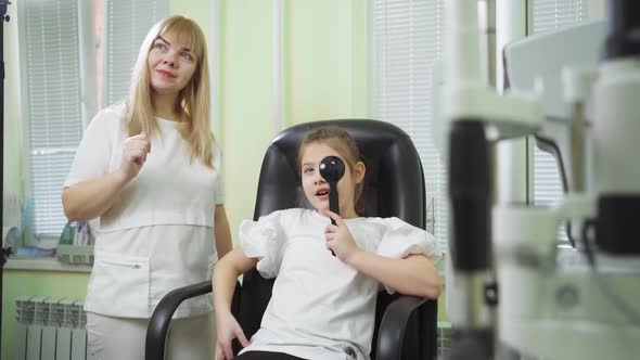 an Ophthalmologist Diagnoses a Little Girl's Vision on a Sign Projector