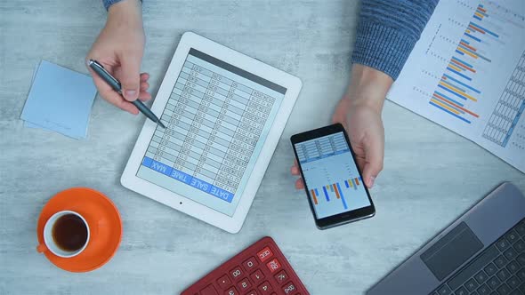 Businessman Using Mobile Phon And Tablet With Financial Data