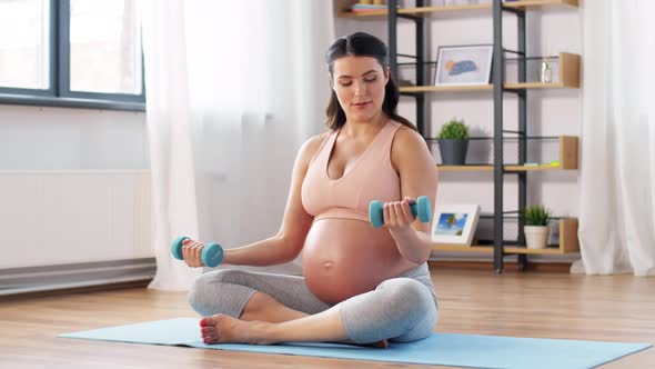 Pregnant Woman with Dumbbells Doing Sports at Home