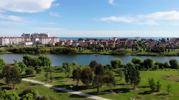 . Aerial Drone Shot. Lake View in a City Park Sunny Day.