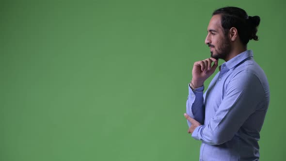 Profile View of Young Handsome Bearded Indian Businessman Thinking