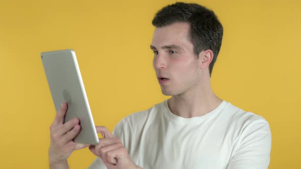 Man Reacting To Loss on Tablet, Yellow Background