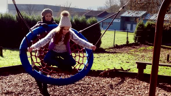 Mother and daughter play on swing