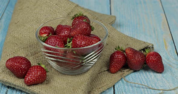 Strawberries in a Small Glass Plate on the Blue Wooden Table