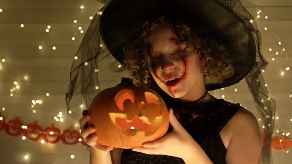 Portrait of a Teenage Girl Dressed As a Witch with Scary Makeup on Her Face