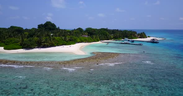 Daytime aerial tourism shot of a white sand paradise beach and aqua blue ocean background in colorfu