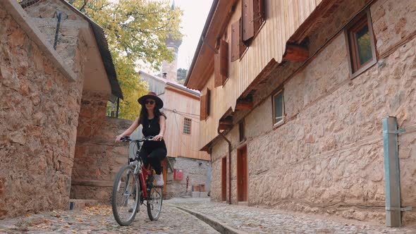 Woman Riding a Bike in the Historic Street