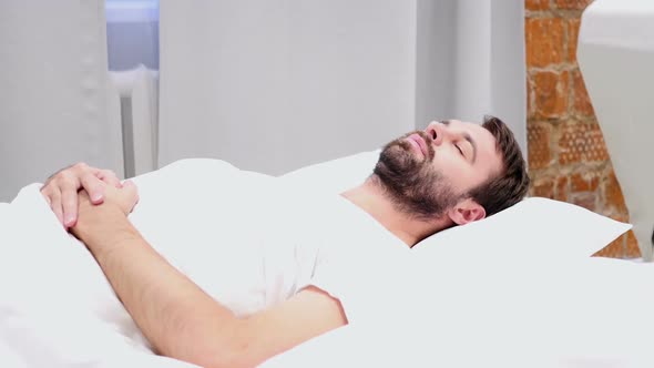 Beard Man Lying in Bed and Sleeping Relaxing After Hard Day